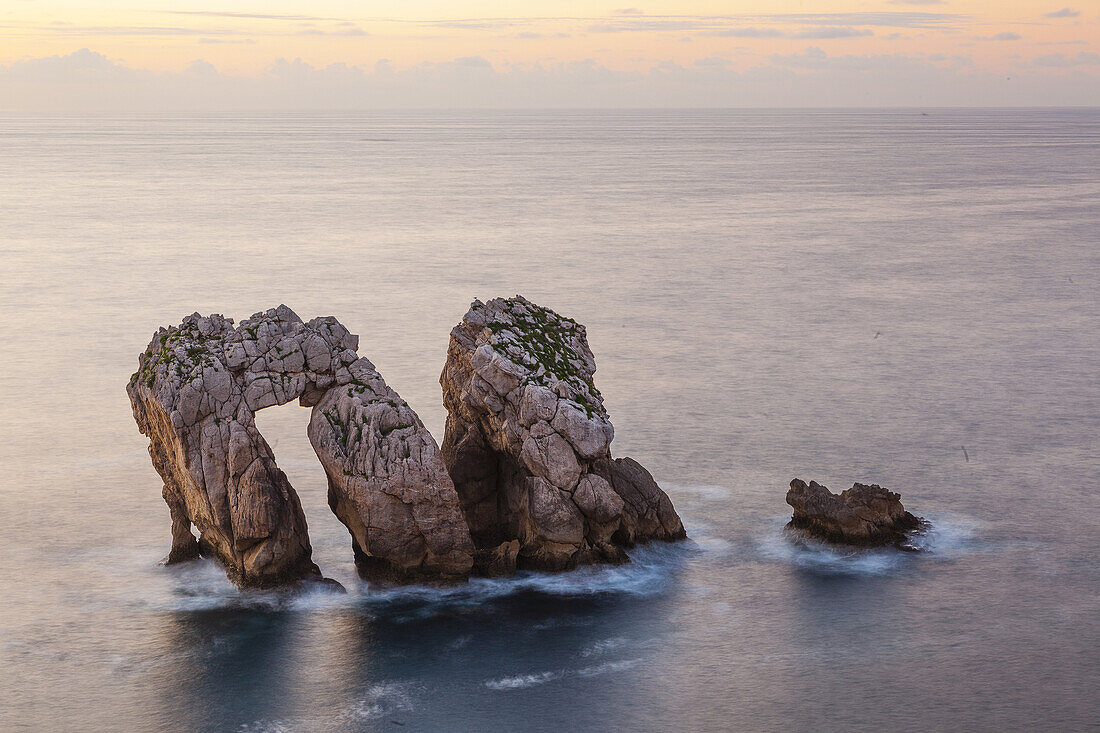 Dramatic arch in rocks Cantabria coast at sunset
