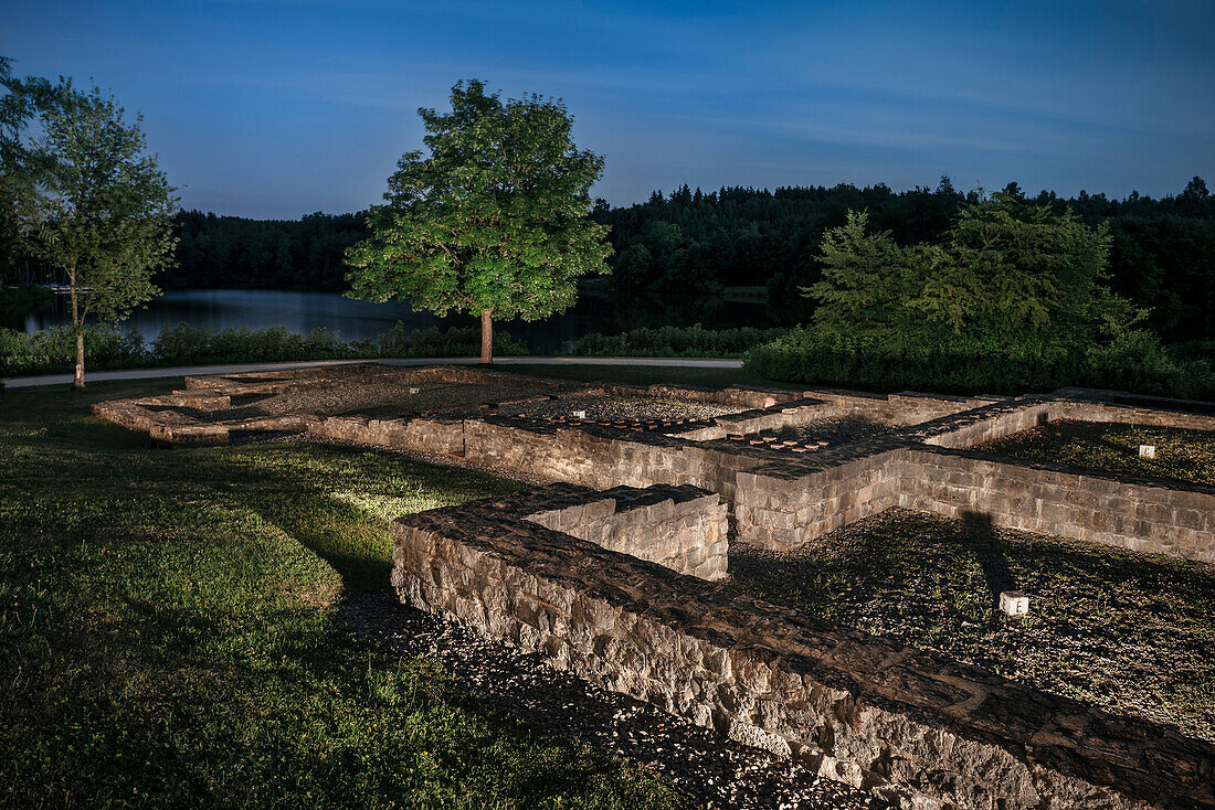 ruins of bathing temple in front of lake at night, Limes (border wall of Roman Empire) Rainau-Buch Park, Aalen, Ostalb province, Swabian Alb, Baden-Wuerttemberg, Germany, UNESCO world heritage site