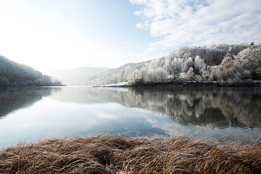 Reflection of a winter wonderland landscape in Lake Edersee, Lake Edersee, Hesse, Germany, Europe