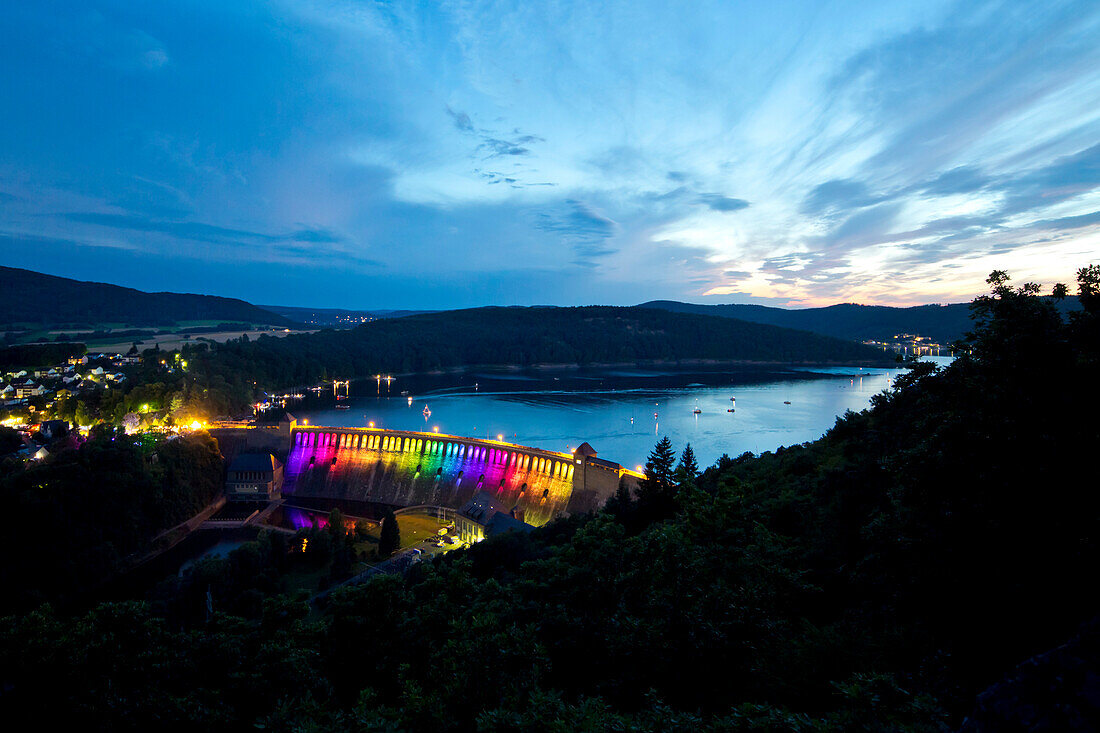 Edertalsperre dam at Lake Edersee in Kellerwald-Edersee National Park illuminated by a colorful light installation at dusk, Lake Edersee, Hesse, Germany, Europe