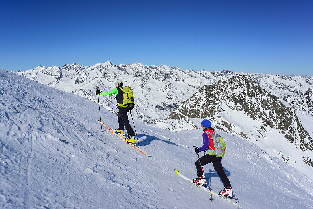 Man and woman back-country skiing ascending towards Schneespitze, Schneespitze, valley of Pflersch, Stubai Alps, South Tyrol, Italy