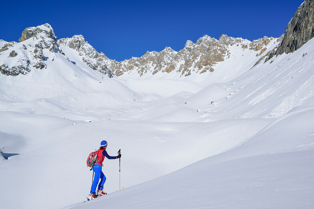 Woman back-country skiing ascending to Col Sautron, Monte Sautron in background, Col Sautron, Valle Maira, Cottian Alps, Piedmont, Italy