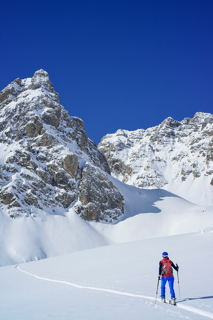 Frau auf Skitour steigt zum Col Sautron auf, Monte Sautron im Hintergrund, Col Sautron, Valle Maira, Cottische Alpen, Piemont, Italien