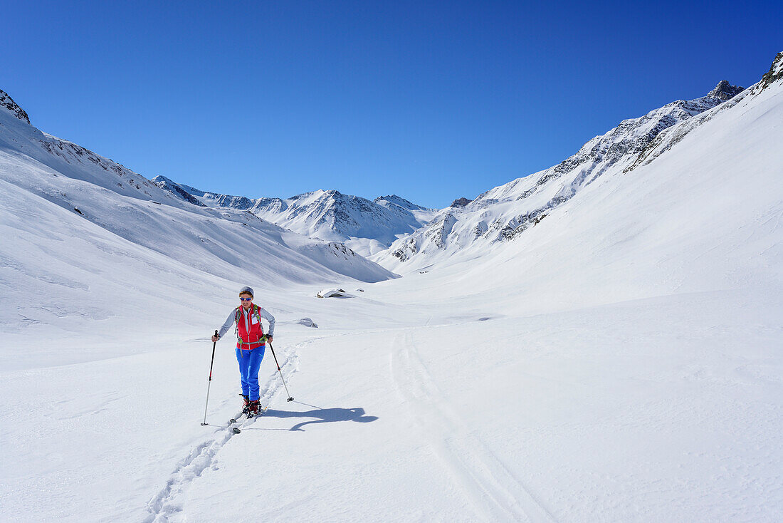 Woman back-country skiing ascending towards Monte Salza, in background Monte Pence and Buc Faraut, Monte Salza, Valle Varaita, Cottian Alps, Piedmont, Italy