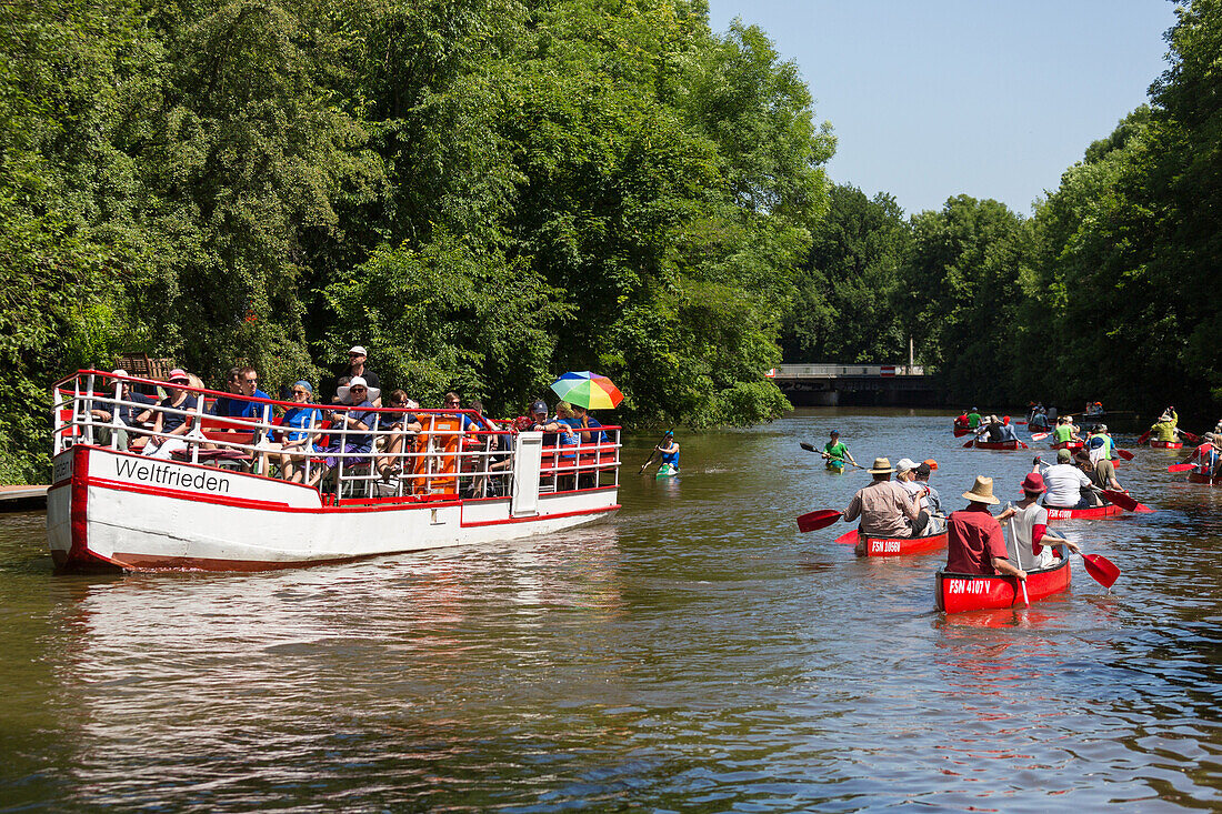 Canoes and excursion boat passing a canal, Plagwitz, Leipzig, Saxony, Germany