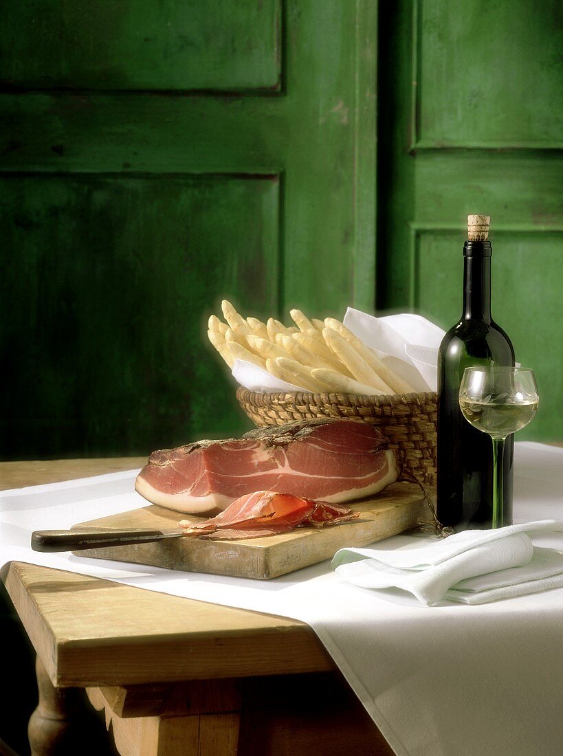 Still life with asparagus, ham and white wine