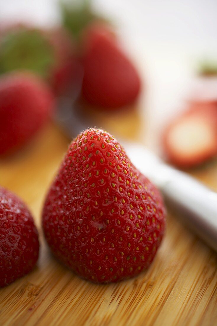 Fresh Strawberries with Stems Cut Off, On Cutting Board