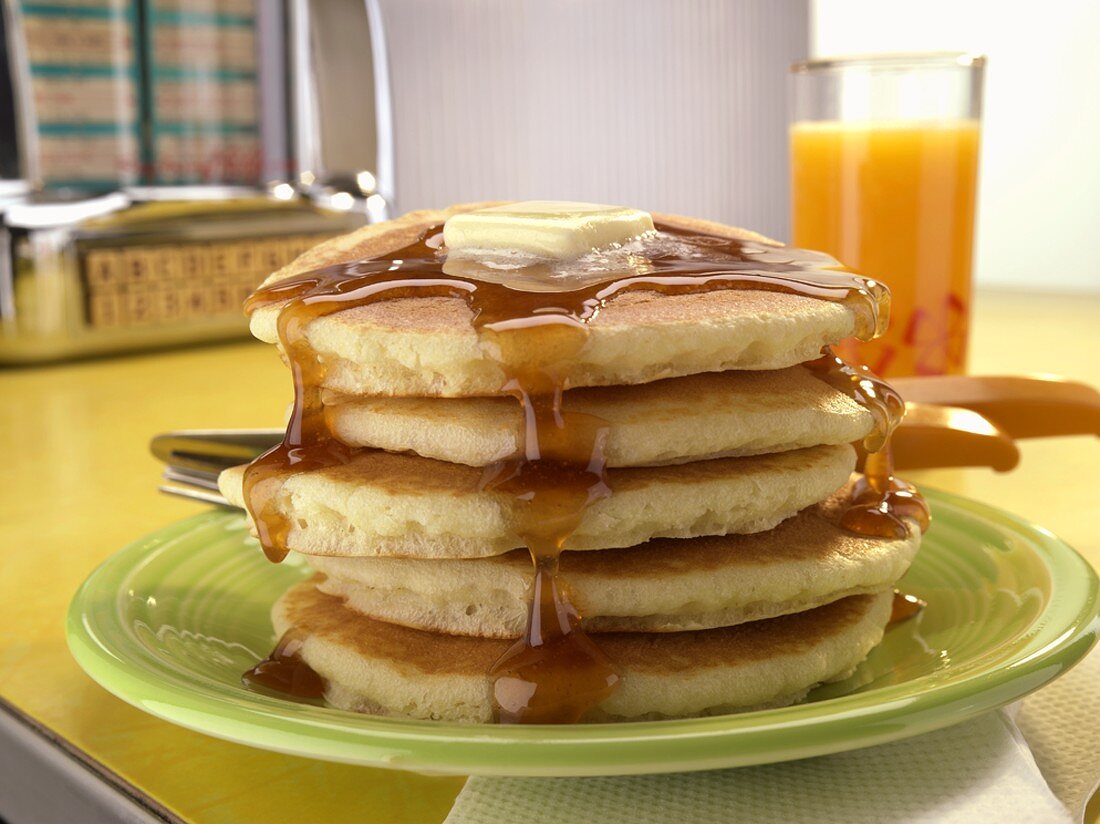 Tall Stack of Pancakes with a Pat of Butter and Maple Syrup
