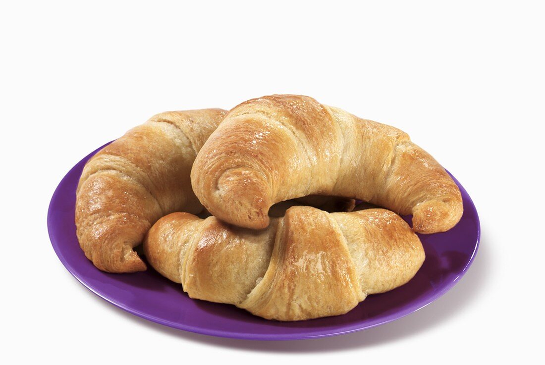 Three Crescent Rolls on a Plate, White Background