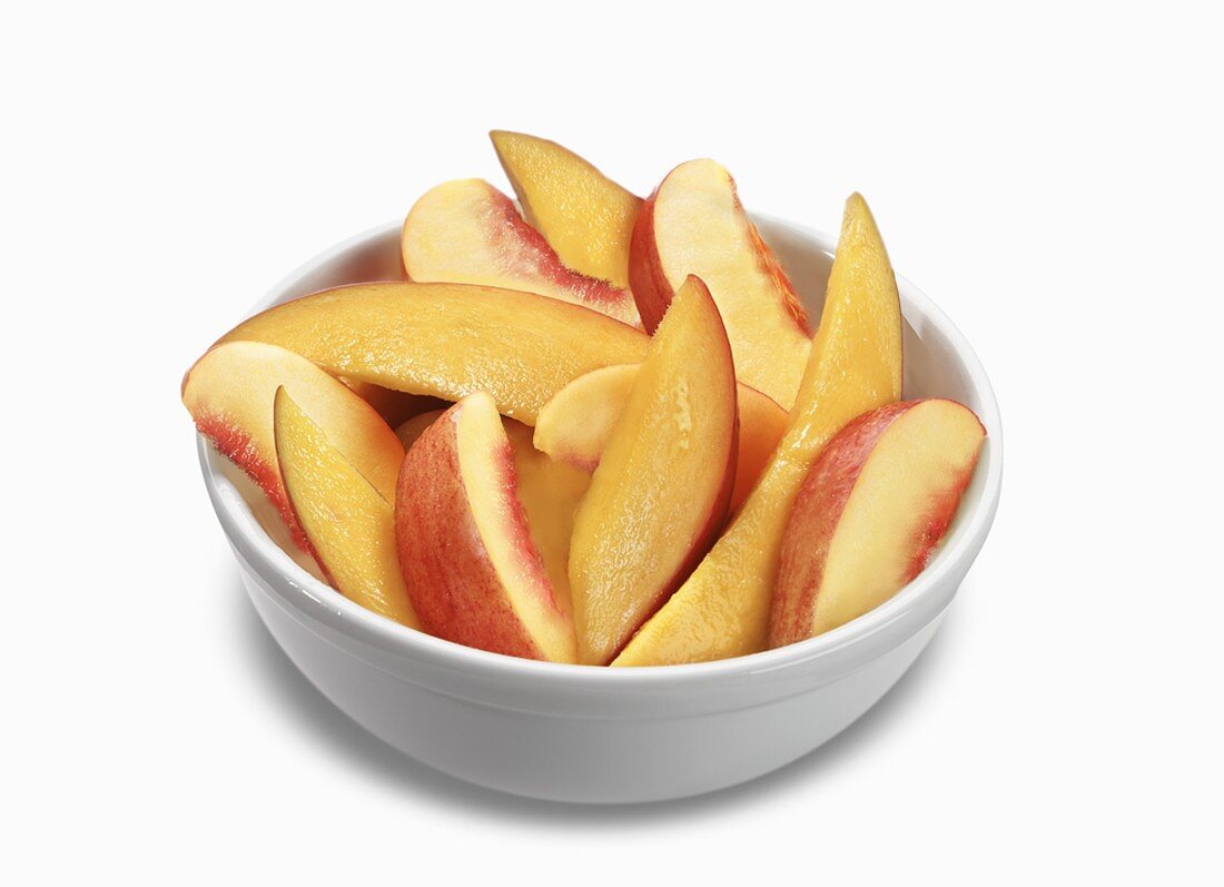 Bowl of Peach and Mango Slices on a White Background