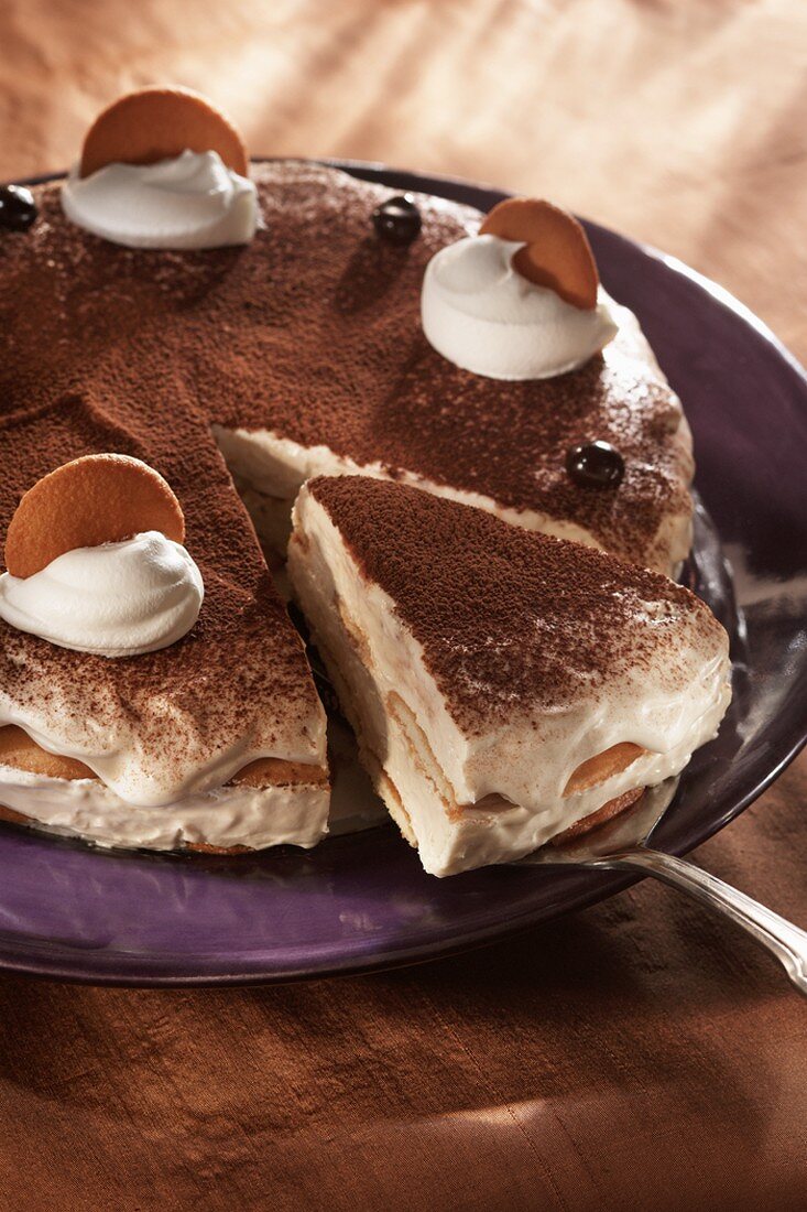 Tiramisu, angeschnitten, mit Stück auf Heber