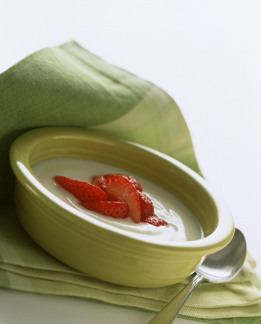A Bowl of Vanilla Yogurt with Slice Strawberries