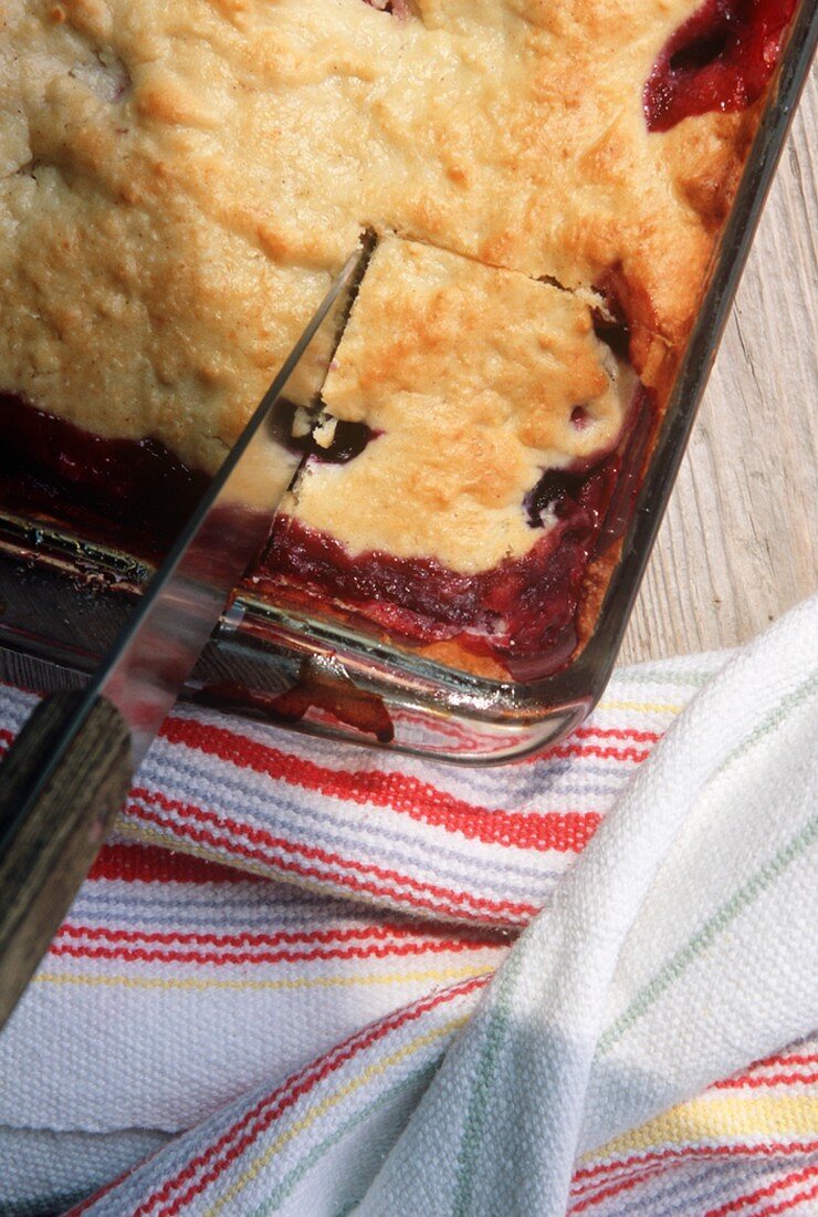 A Kinfe Cutting into Blueberry Cobbler