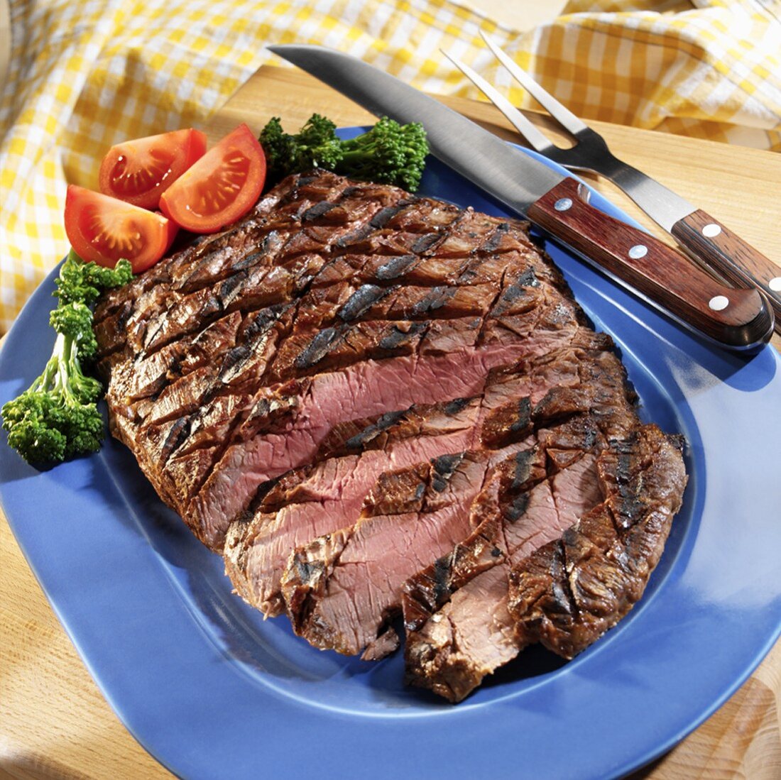 Grilled, Sliced Flank Steak on a Blue Platter