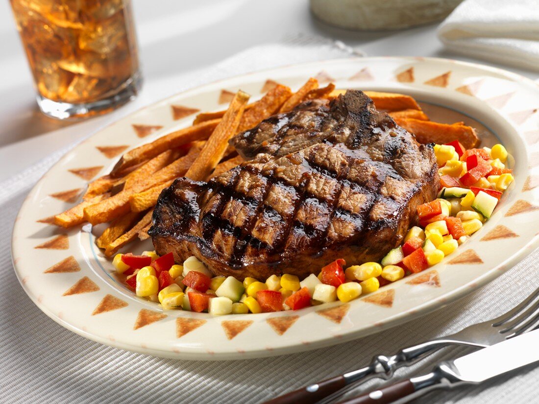 A Grilled Pork Chop with Corn Relish and Sweet Potato Fries