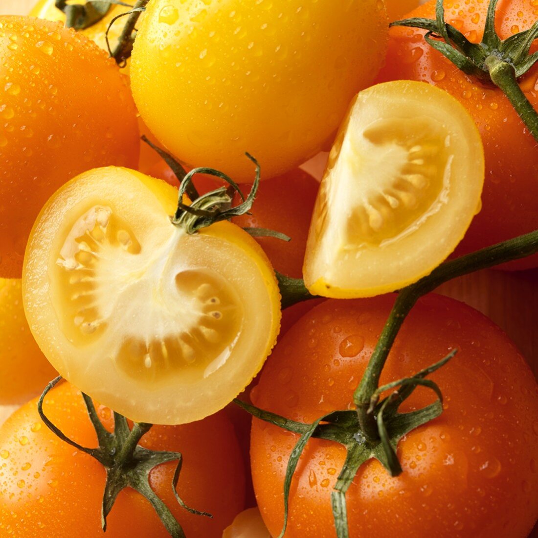 Gelbe und orangefarbene Tomaten mit Wassertropfen