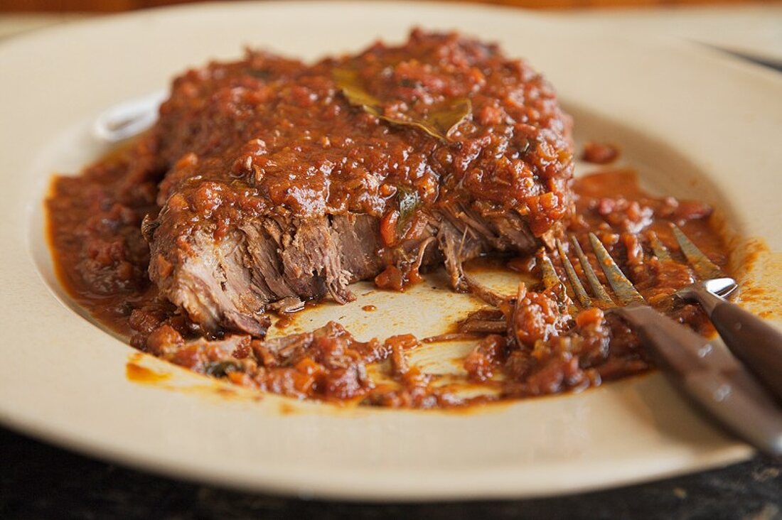 Partially Eaten Swiss Steak on a Plate with a Fork