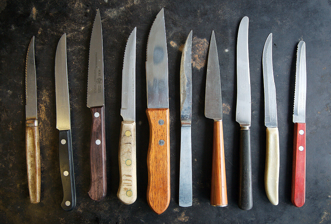 Many Assorted Steak Knives Lined Up
