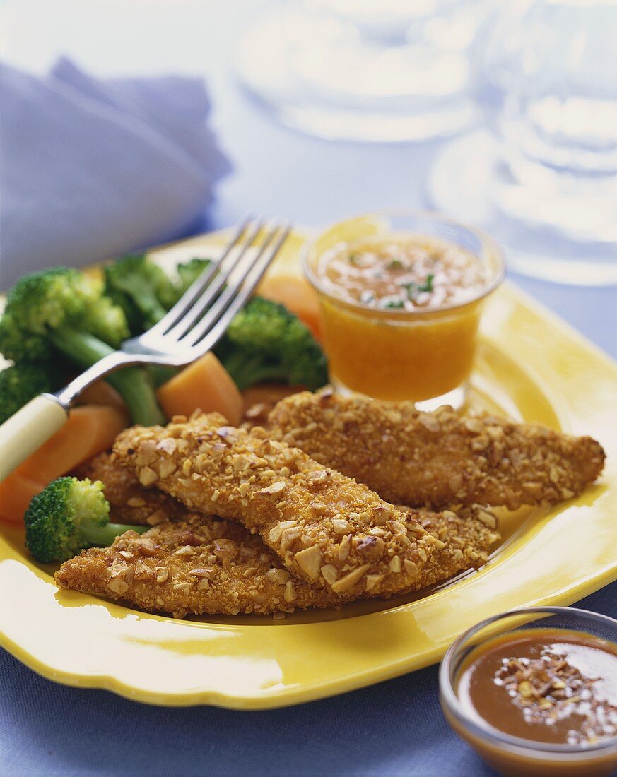 Nut Crusted Chicken Tenders on a Plate with Carrots and Broccoli, Dipping Sauce