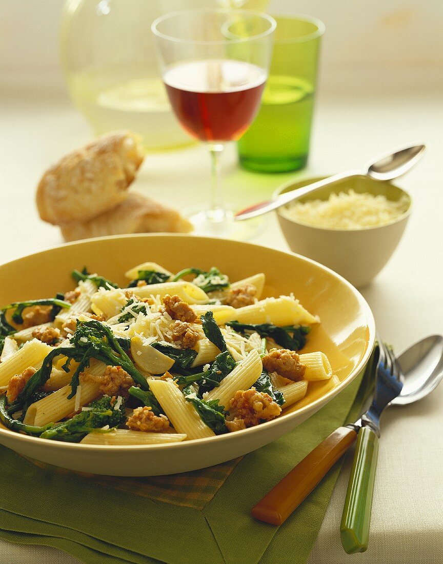 Bowl of Penne Pasta with Broccoli Rabe and Sausage Topped with Parmesan Cheese
