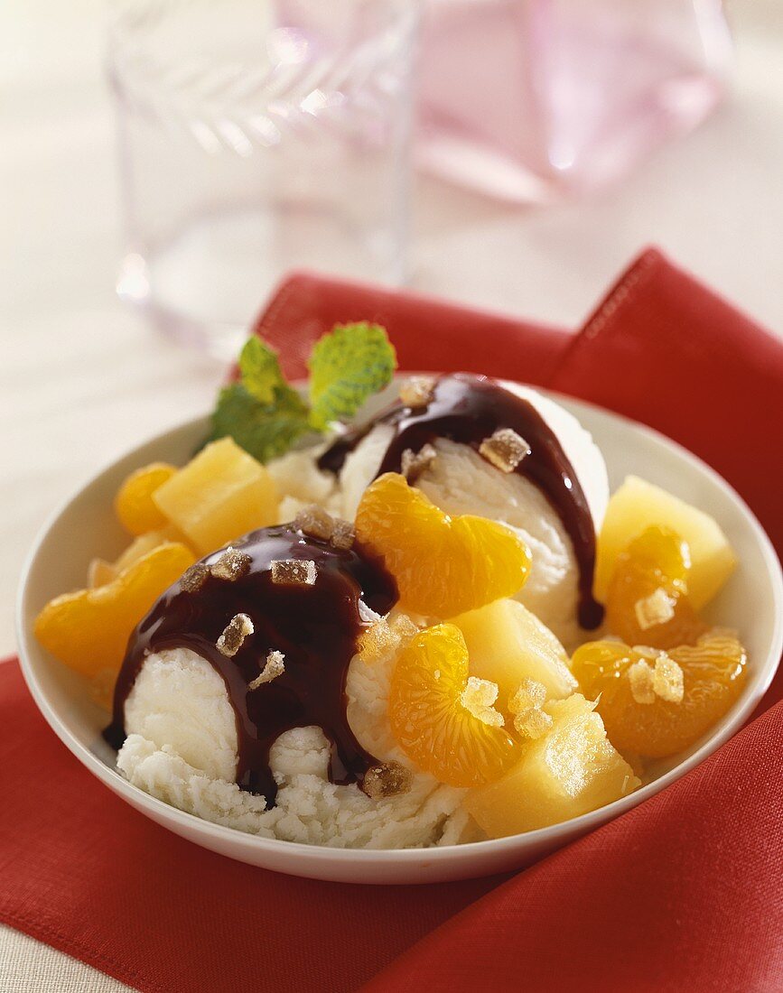 Two Scoops of Vanilla Ice Cream with Chocolate Sauce and Fruit Compote in a Bowl