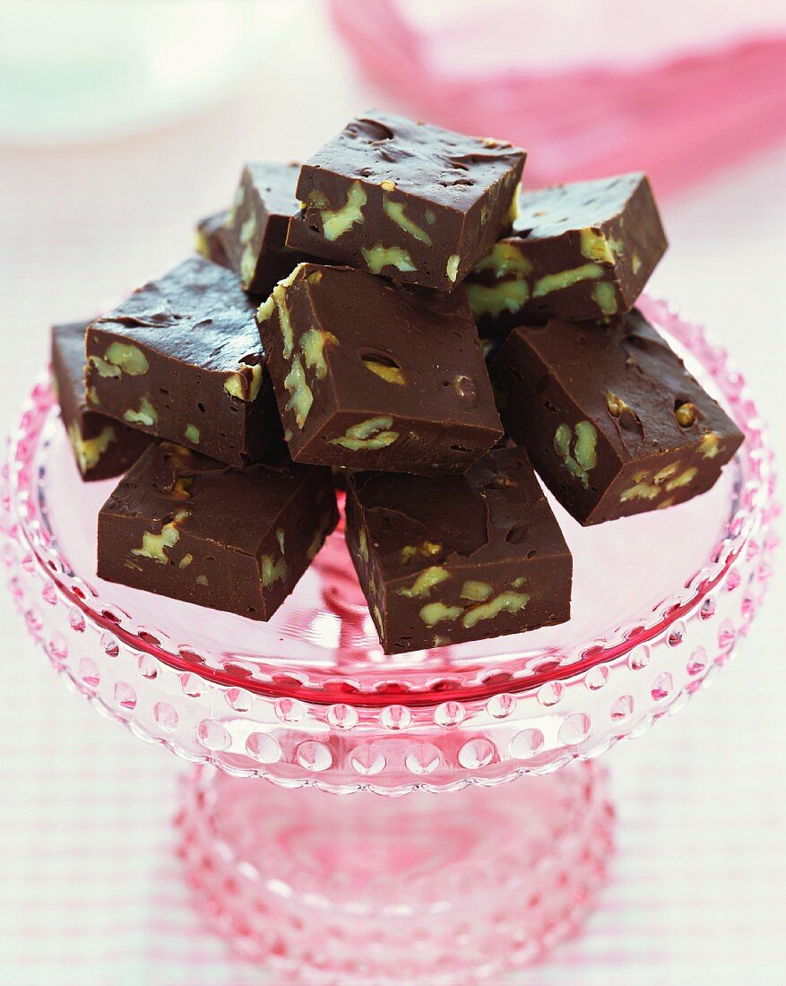Pecannuss-Schokoladen-Konfekt auf rosa Kuchenplatte