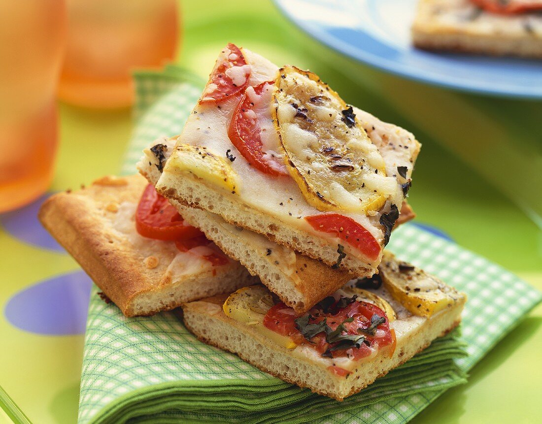 Square Pieces of Tomato Zucchini Pizza on Folded Cloth Napkin