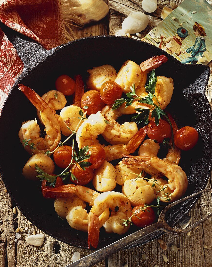 Shrimps, Jakobsmuscheln und Tomaten in Gusseisenpfanne