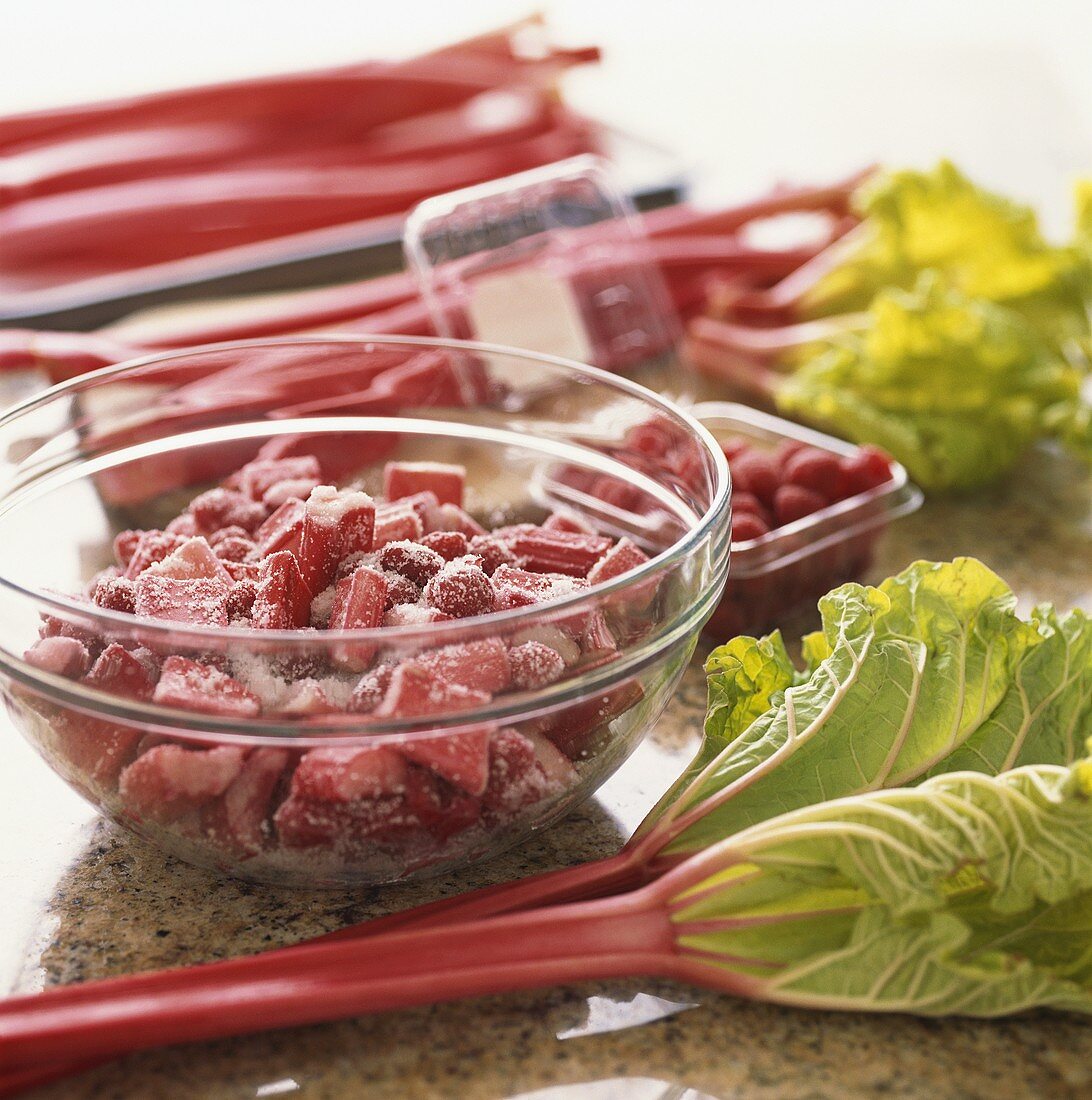 Rhabarber und Himbeeren, mit Zucker vermischt, in Glasschale