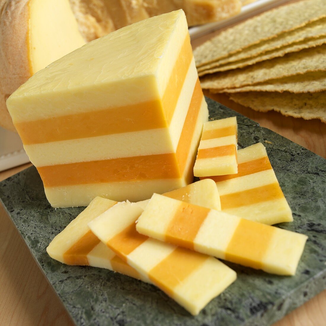 Ein Viertel Laib Ilchester-Käse und einige Stückchen davon auf einer Marmorplatte