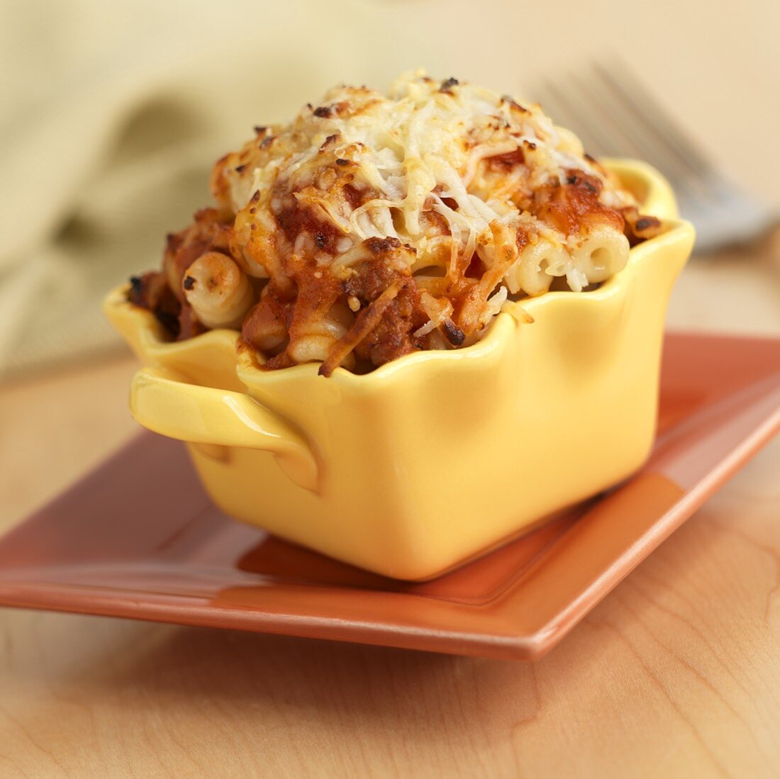 Pasta with Meat Sauce Topped with Cheese Baked in an Individual Dish