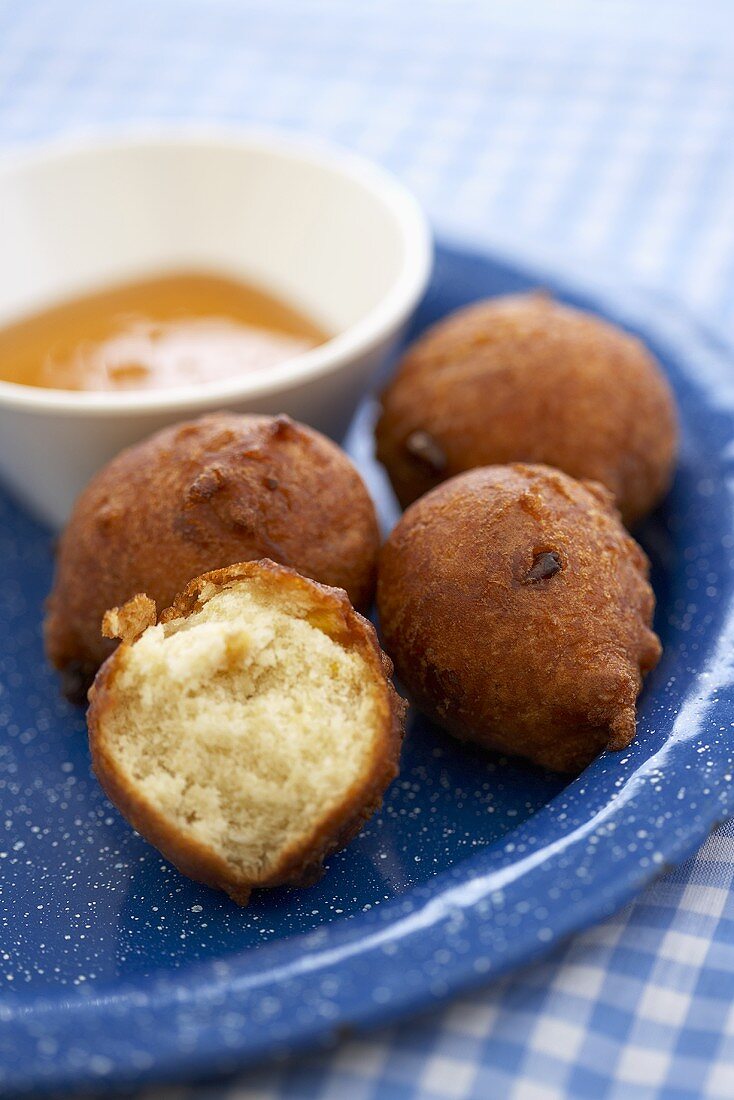 Hush Puppies on a Plate with Honey; One Broken Open; Corn Fritters