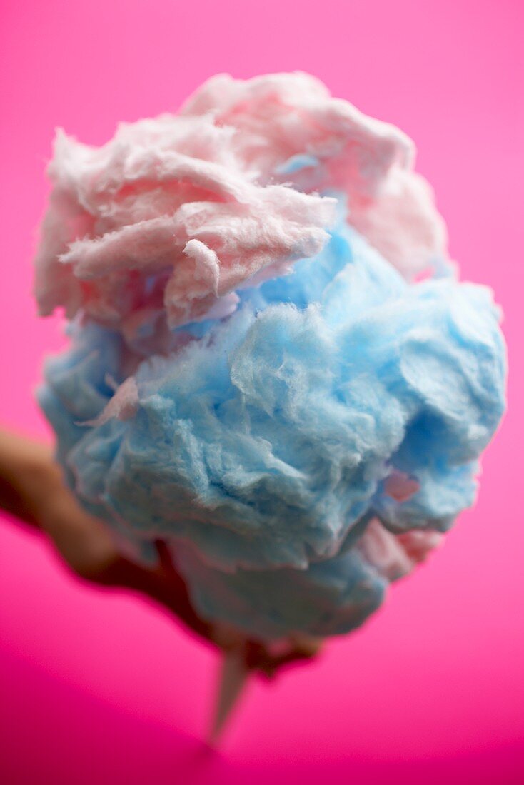 Blaue & rosafarbene Zuckerwatte vor pinkem Hintergrund