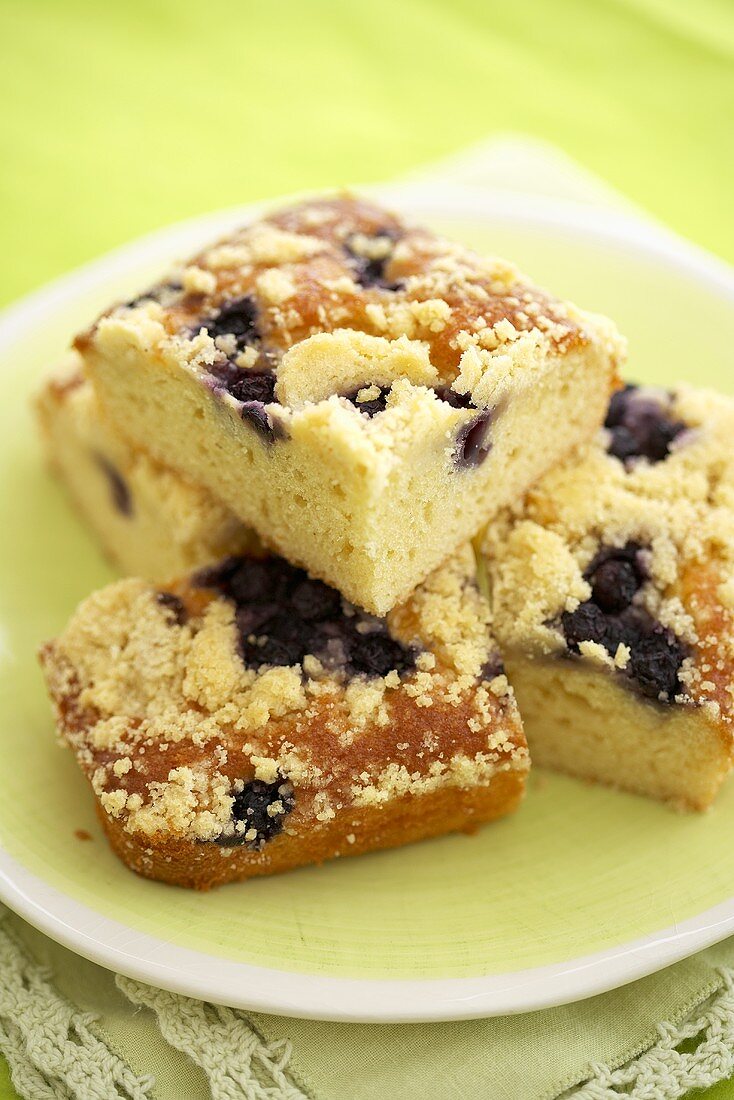 Pieces of Blueberry Crumb Coffee Cake Stacked on a Plate