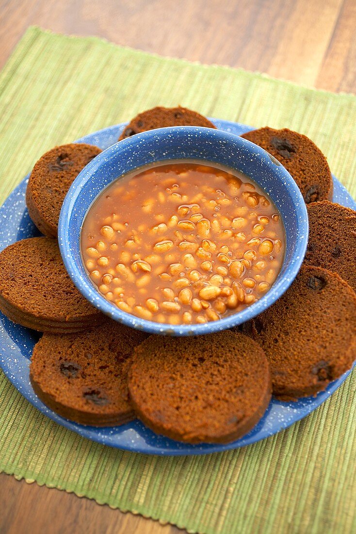 Slices of Boston Brown Bread with Raisins with a Bowl of Baked Beans