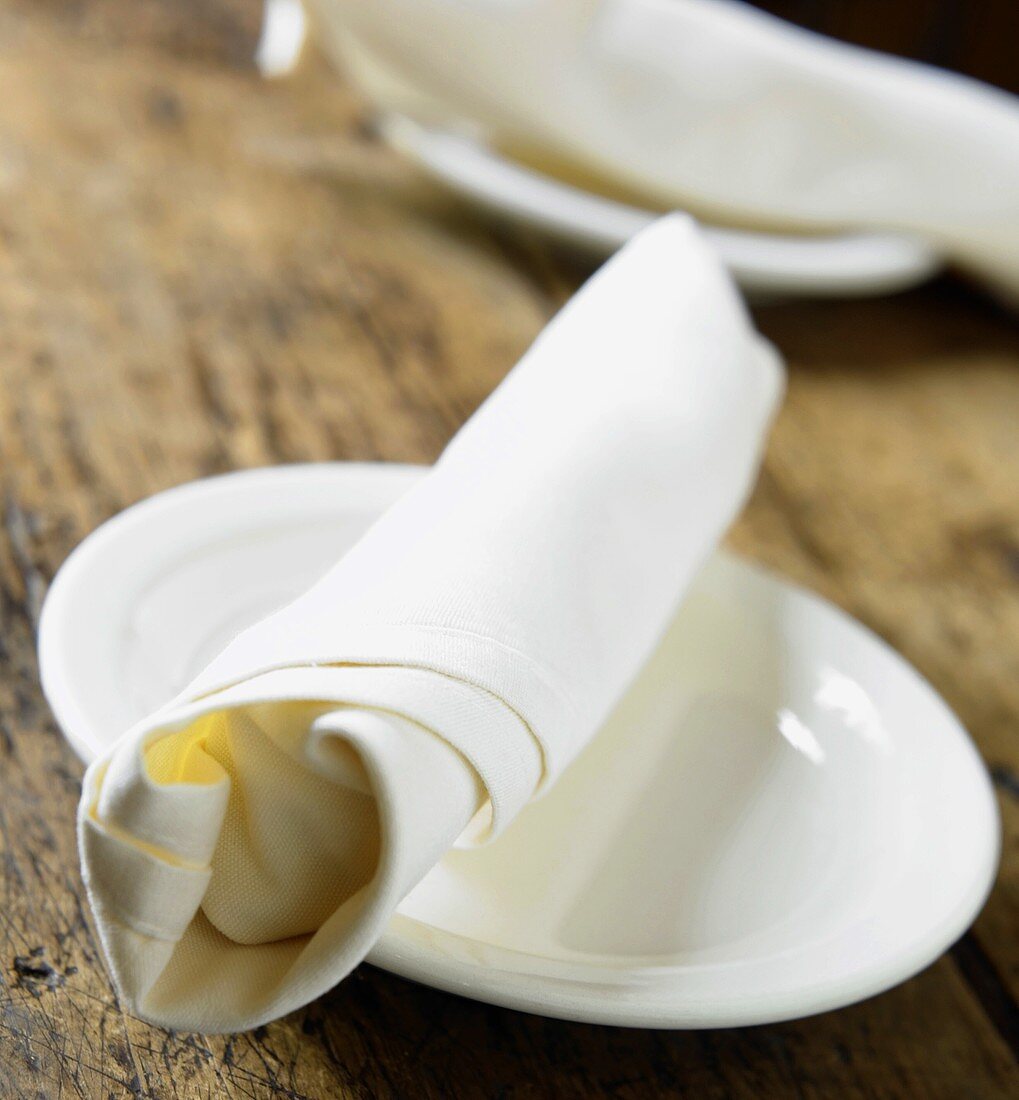 Two Plates with White Fabric Napkins on Wooden Table