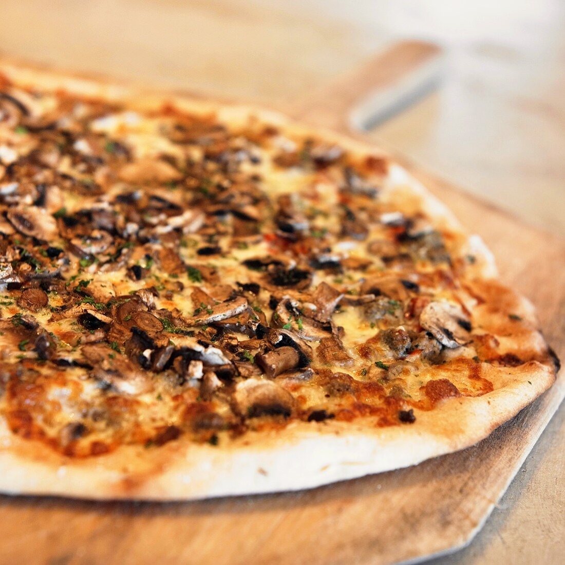 Pizza mit Pilzen auf Holzbrett