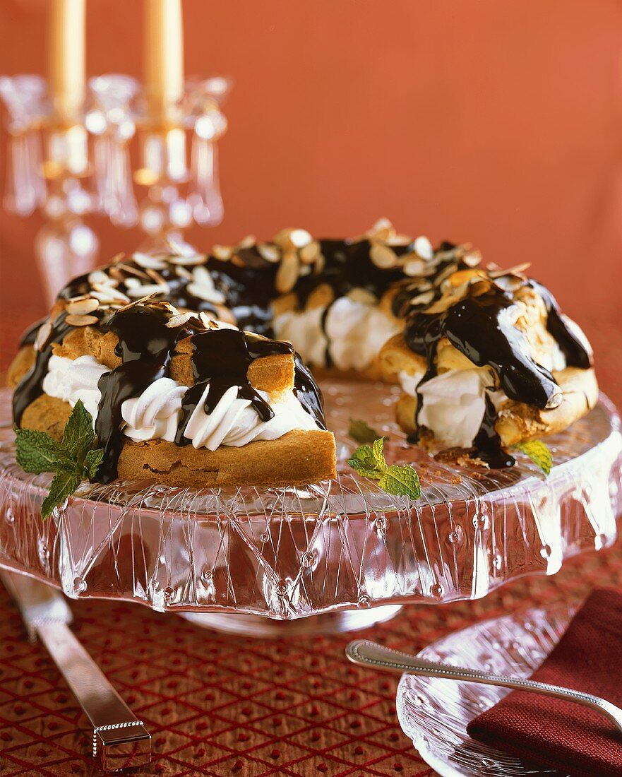 Cream Filled Pastry Dessert with Chocolate Sauce and Almonds; Slice Removed