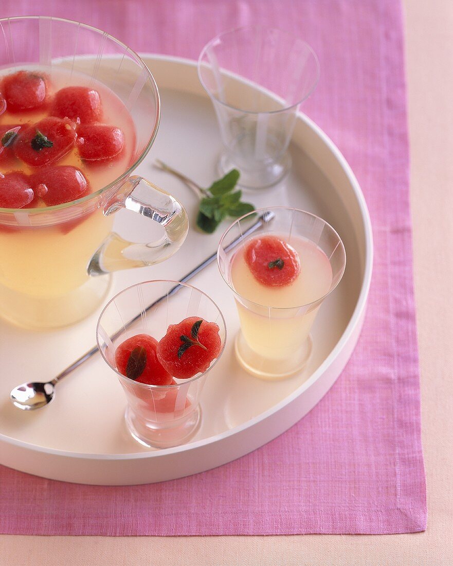 Limonade mit Wassermeloneneiswürfeln in Krug und Gläsern