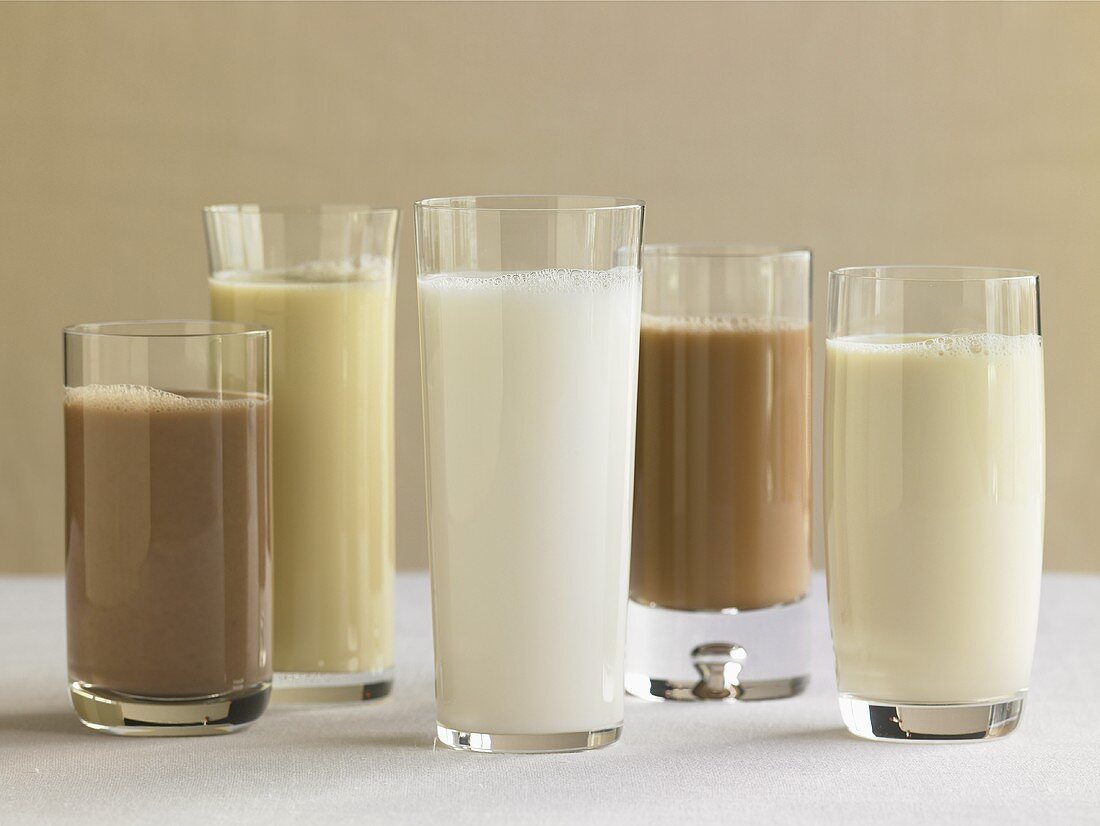 Fünf Gläser mit Milch und verschiedenen Milchgetränken