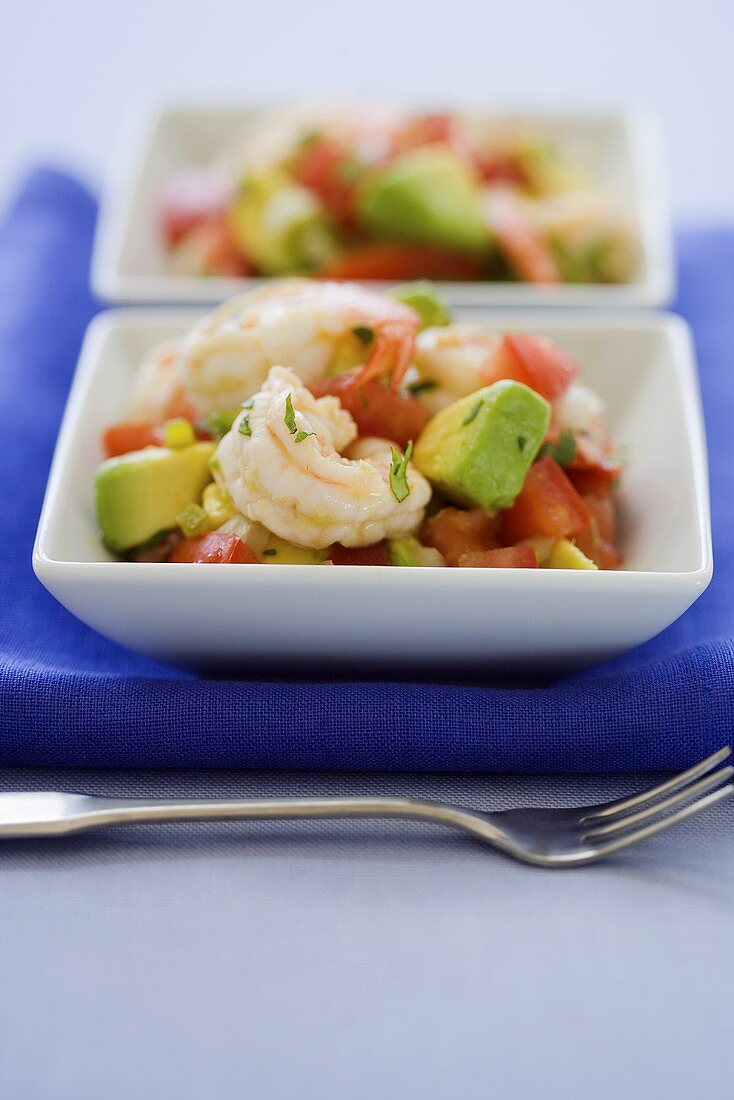 Avocado-Tomaten-Salat mit Shrimps und Basilikum in zwei Schälchen