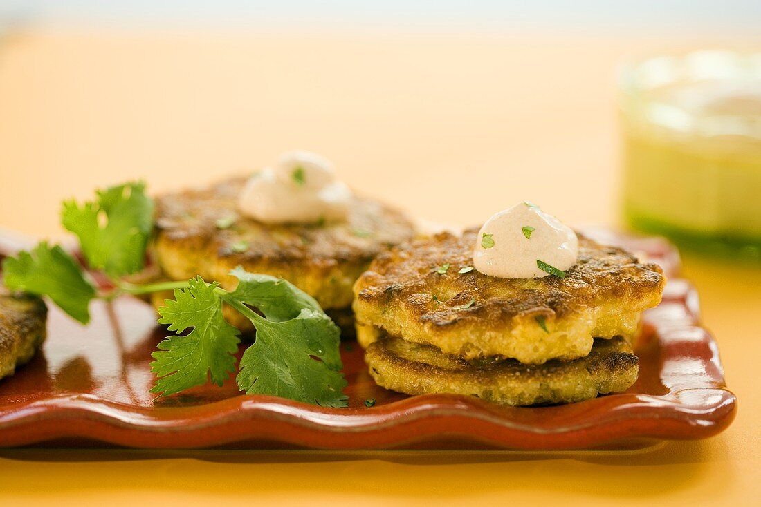 Corn Fritters with Dollops of Cream and Parsley Garnish