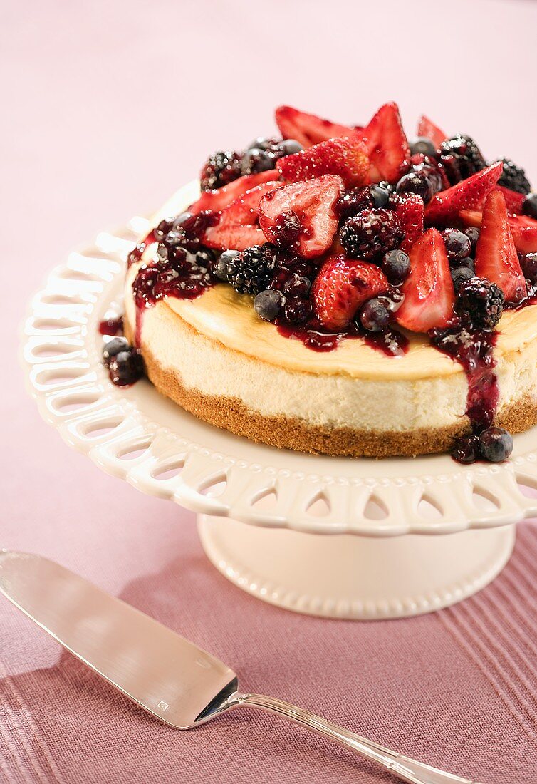 Ein Käsekuchen mit marinierten Beeren auf einer Tortenplatte