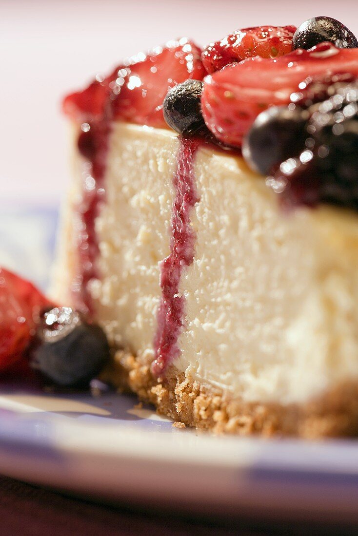 Ein Stück Käsekuchen mit marinierten Beeren (Nahaufnahme)