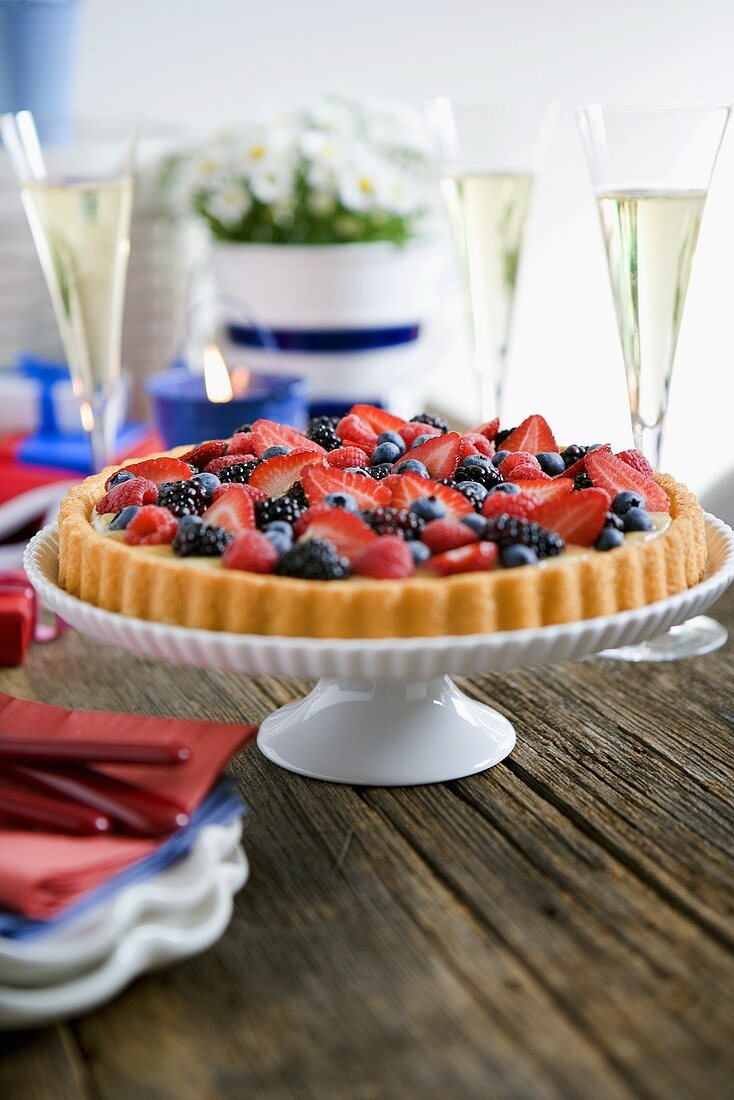 Whole Fruit Tart on a Pedestal Dish on a Wooden Table