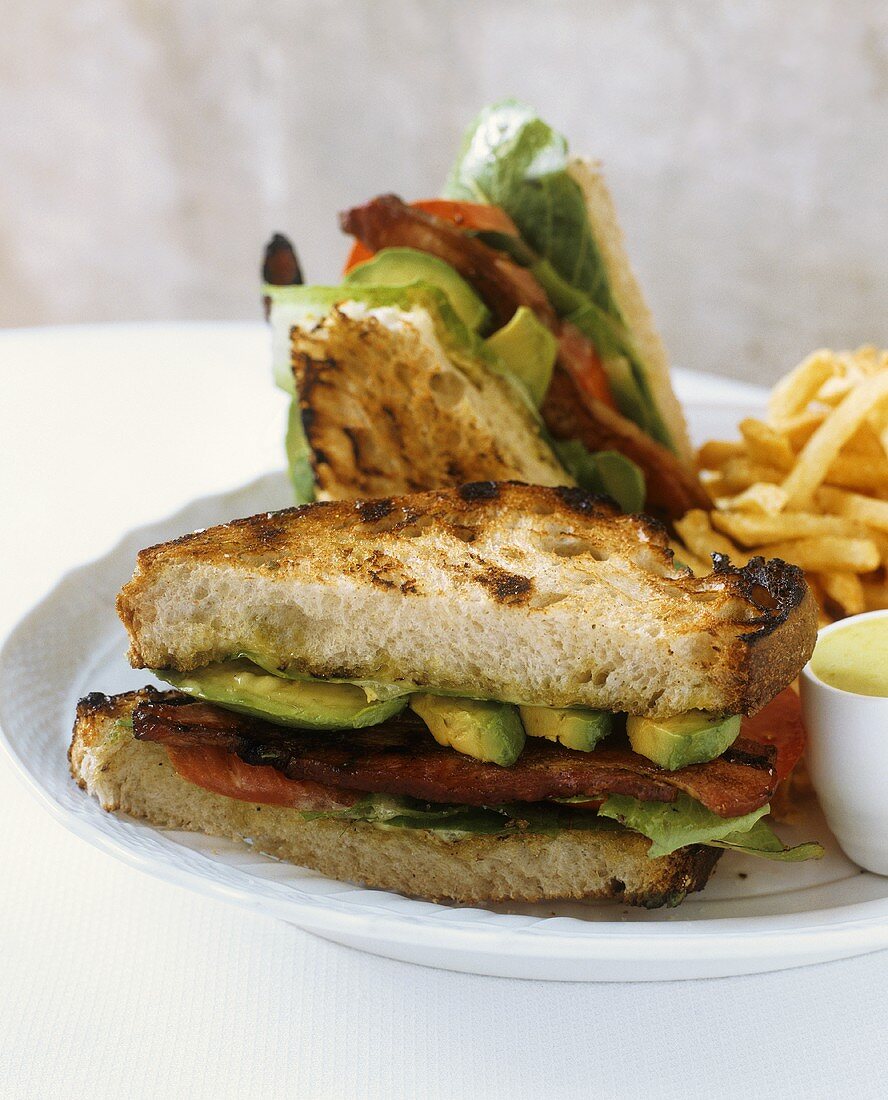 BLT with Avocado on Toasted Bread; Halved with French Fries