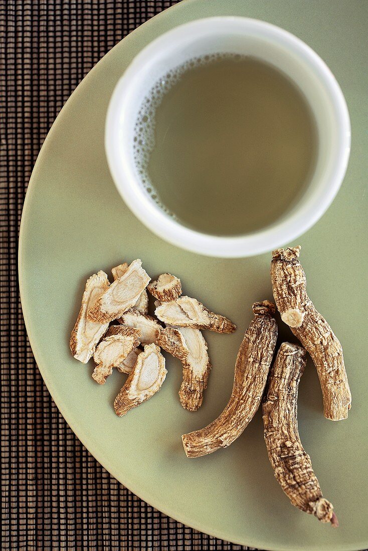 Ginsengwurzelstücke und eine Tasse Ginseng Tea