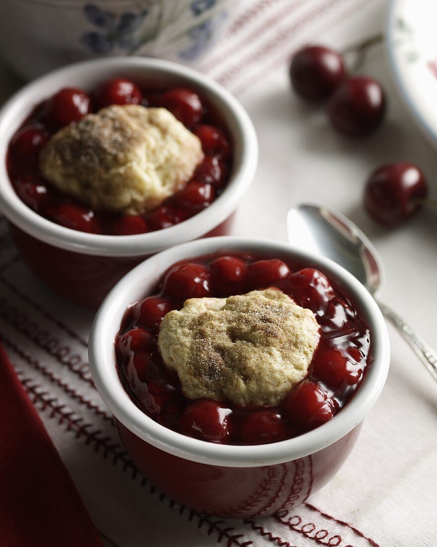 Zwei Kirsch-Cobbler mit Zimtzucker in Dessertschalen