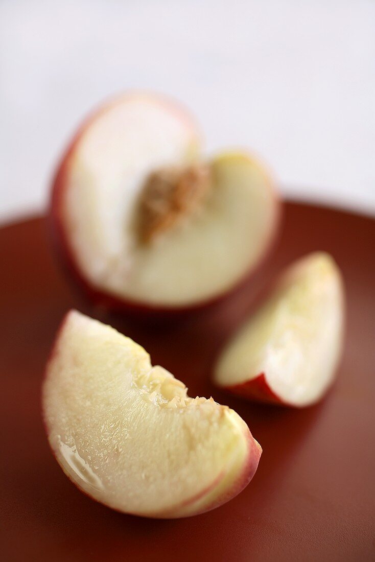 Two Slices of a White Peach with Sliced Peach in Background