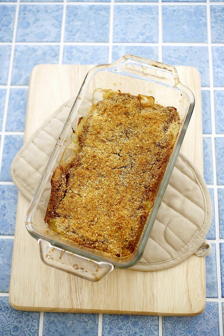 Apple Crisp in Baking Dish on a Pot Holder on Cutting Board, From Above